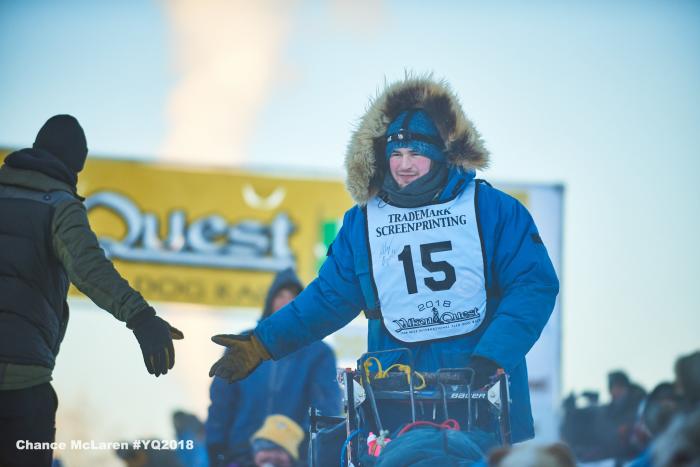 A musher shaking hands with a handler at start of race in Fairbanks