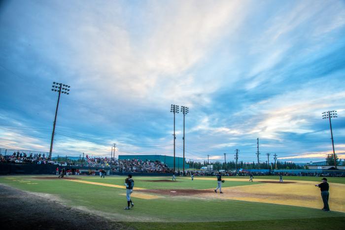 Baseball park with players on field during midnight sun season