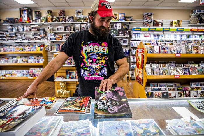 Man looking at comic books at Galactic Quest