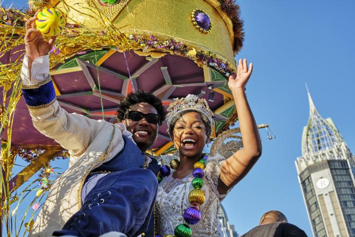 Mardi Gras king and queen waving