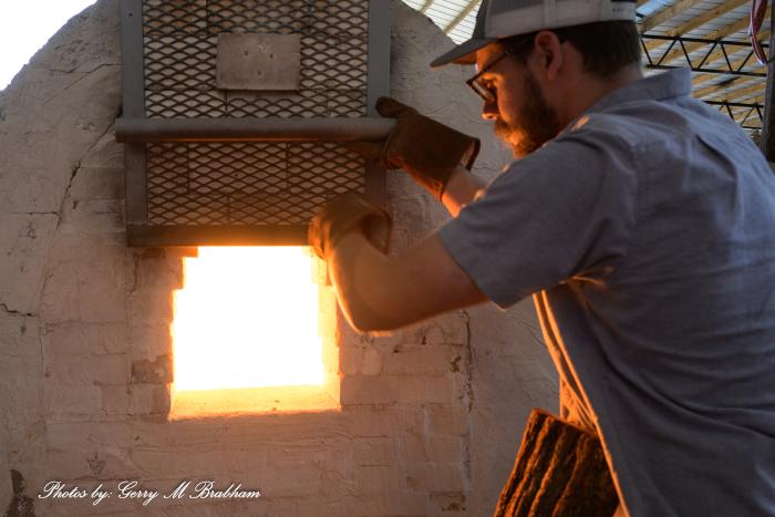 A member of the firing crew tends the wood fired kiln during the first firing at Finch Pottery since 2019 in Bailey, North Carolina.