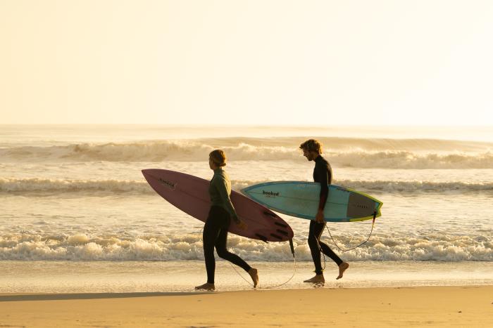 Two surfers explore the shoreline near Nags Head in the Outer Banks.