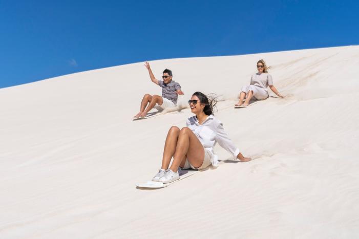 Group sand boarding on the dunes in Lancelin