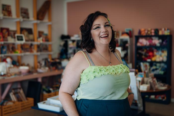 A woman laughing in her craft shop