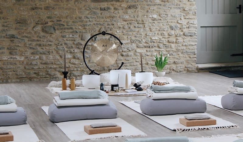 A stone-walled room is ready for the sensory soundbath event with gong, soundbaths and blankets