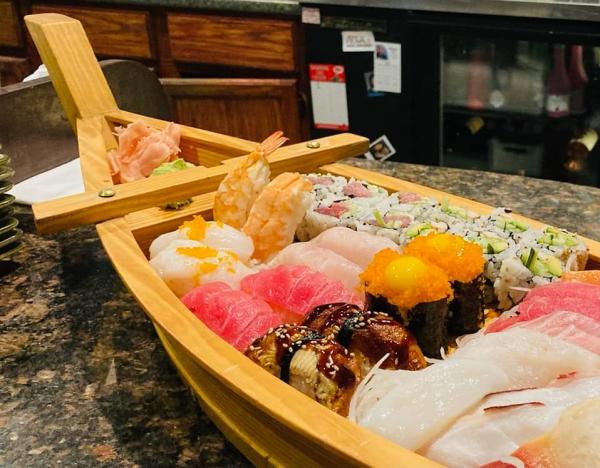 Sushi inside of a wooden boat on a table