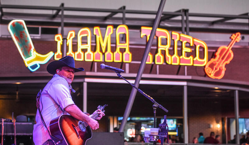 Man with Guitar and cowboys hat on Mama Tried stage