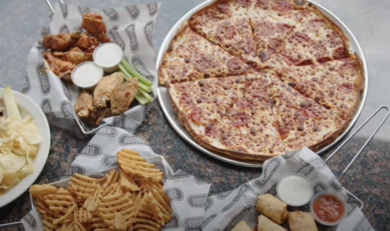 Pizza is served alongside wings and waffle fries at Pumphouse in Wichita