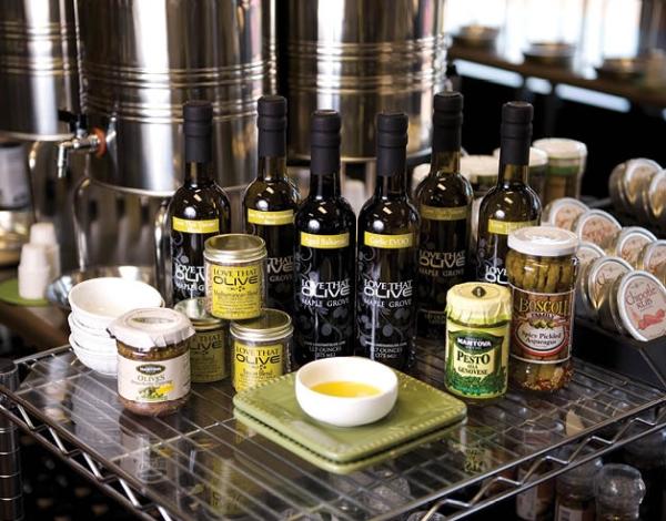 A table full of olive oils, pestos, and other culinary products at Love That Olive
