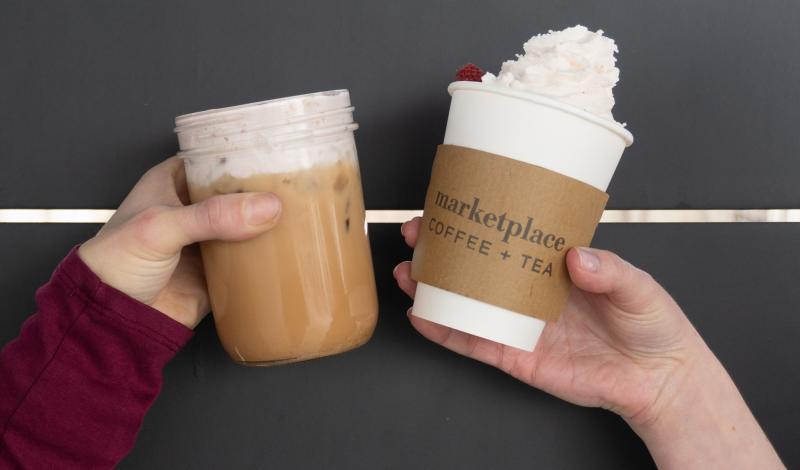 Two people "cheers" with drinks from Poulin Marketplace.