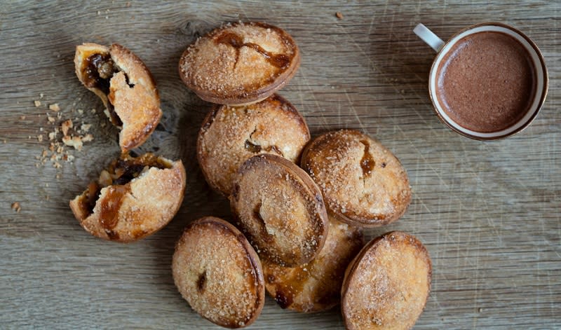 Mince pies heaped on a wooden table