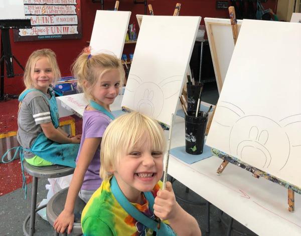 Three kids enjoying a painting class at Painting with a Twist.
