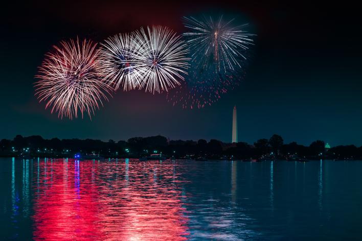 view of DC fireworks over the potomac river with memorials in background