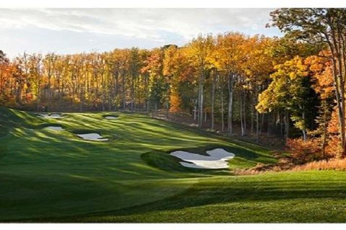 A golf course with trees that have fall foliage