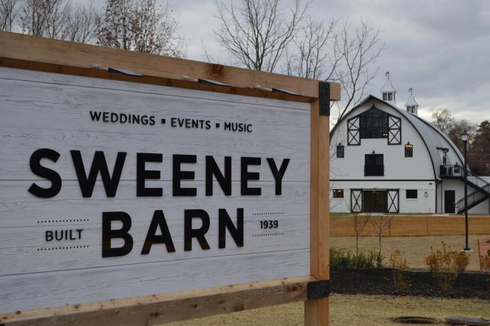 Sweeney Barn sign with building in the background