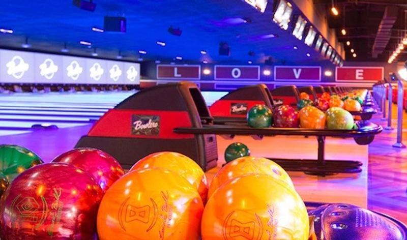 Colorful bowling balls lined up on a ball return at Bowlero Brooklyn Park