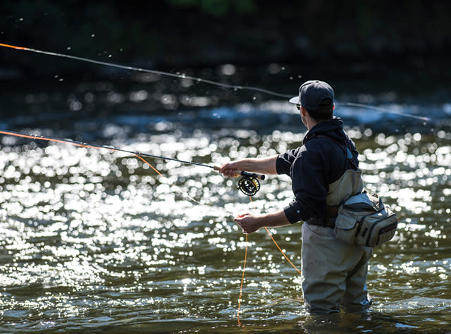 A man fly fishing in the Salmon River in Pulaski
