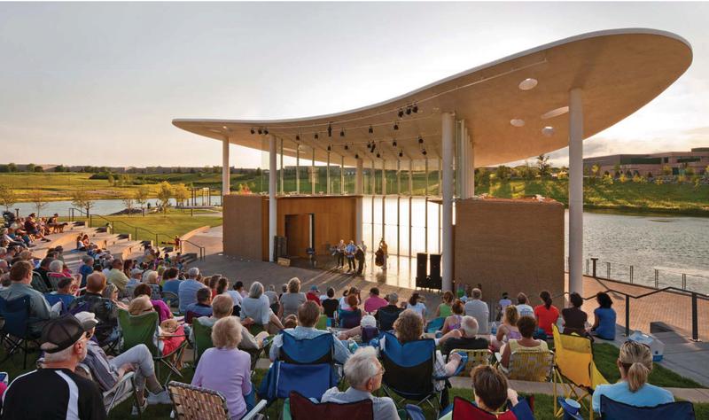 A band performs to a large crowd during an Outdoor summer concert at Town Green Bandshell