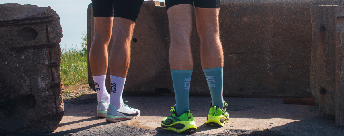 An image focussed on the runnning shoes and ALTUS running socks of two trail runners.
