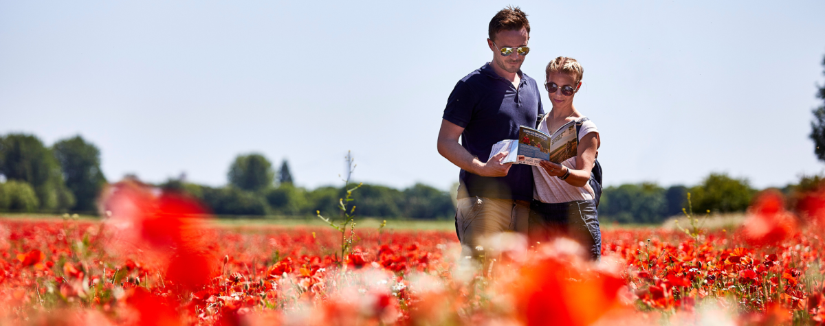 A couple stood in a field of poppies in the Yorkshire Wolds