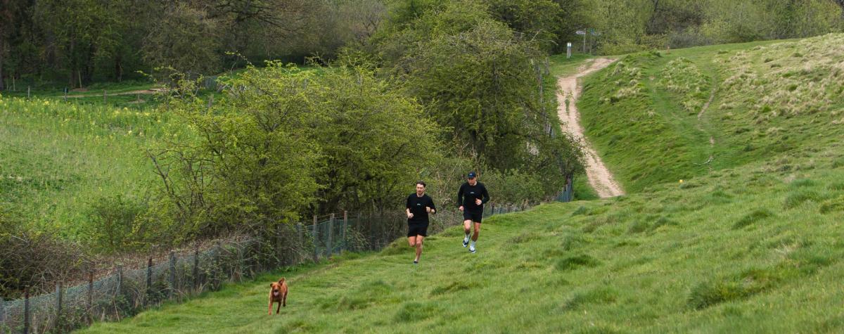 Two runners and their dog following a trails run in the Yorkshire Wolds.