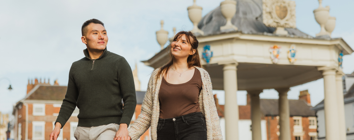 A couple strolling hand-in-hand through Saturday Market in Beverley.