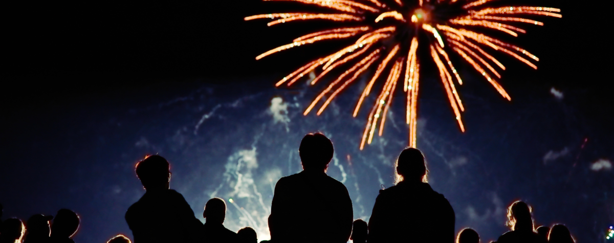 A crowd watching a large fireworks display