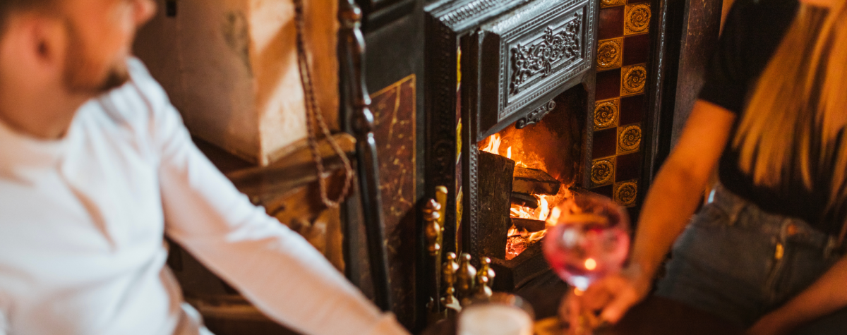 A couple enjoying drinks by the cosy fire at The Goodmanham Arms in East Yorkshire