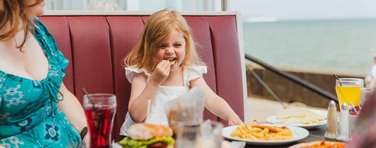 A little girl with her mum enjoying food at Jerome's Pavilion Bar in Bridlington.