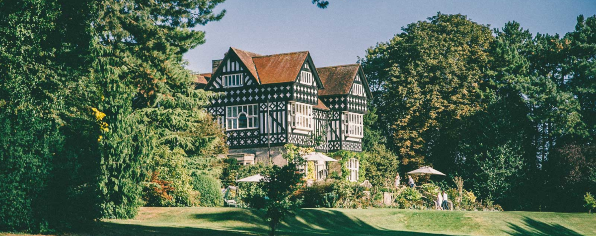 The beautiful gardens of Highfield House in East Yorkshire with the historic black and white building in the distance