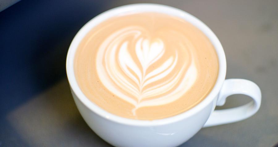 A cappuccino with a floral design in the foam