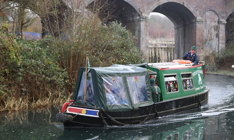 A canal boat cruises along the canal with Santa and guests on board