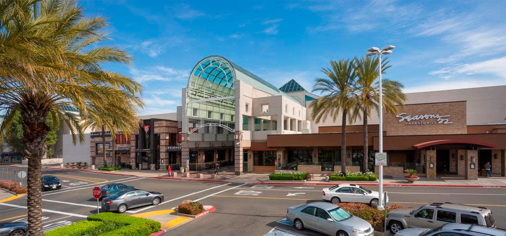 Arden Fair Mall entrance under clear sky, viewed from parking lot