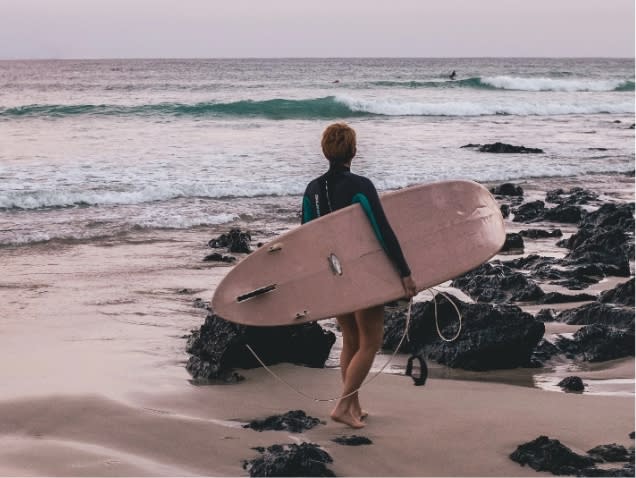 Surfer on rocky beach