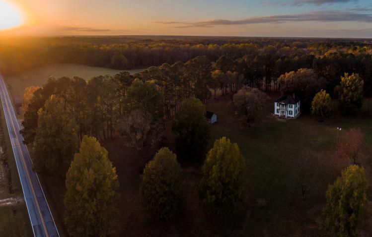 The sunsets in autumn over the fields and historic buildings of Bentonville Battlefield