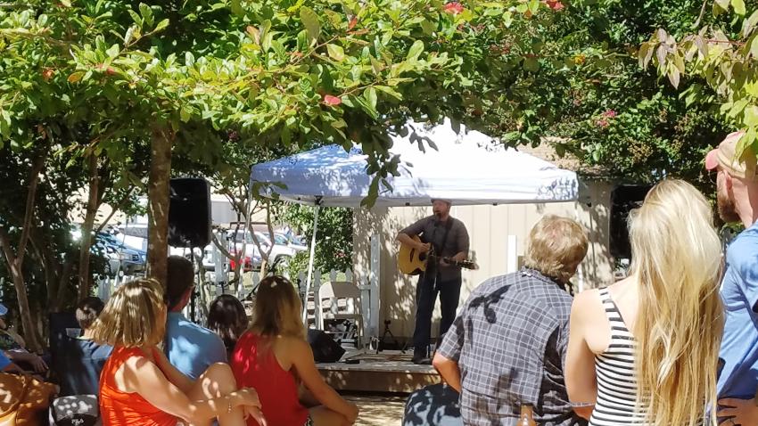 Man Playing Guitar Under a Tent During the Carrboro Music Festival