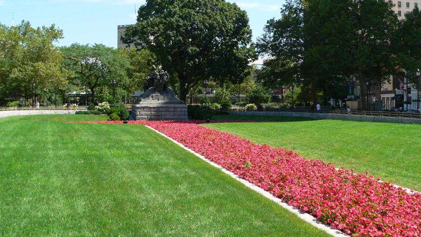 red flowers leading up to sculpture in Military Park