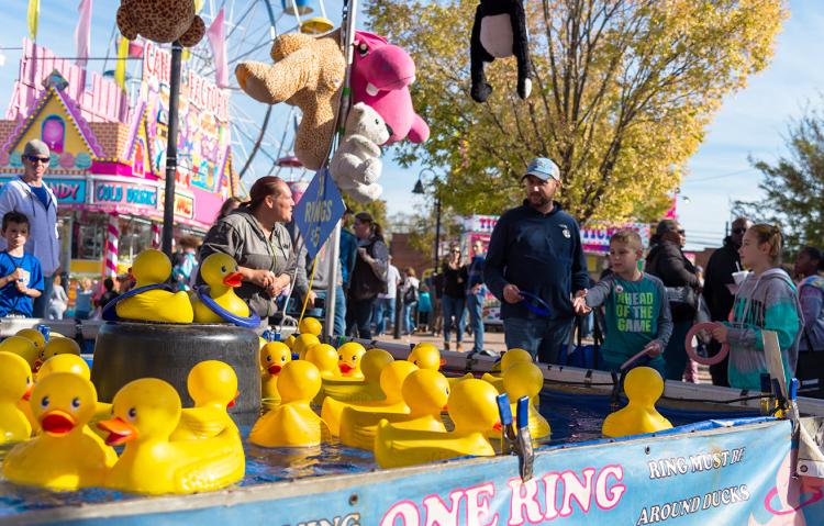 A family playing carnival games at the Clayton Harvest Festival in Johnston County, NC.