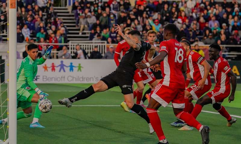 Oakland Roots player kicking the ball into the goal