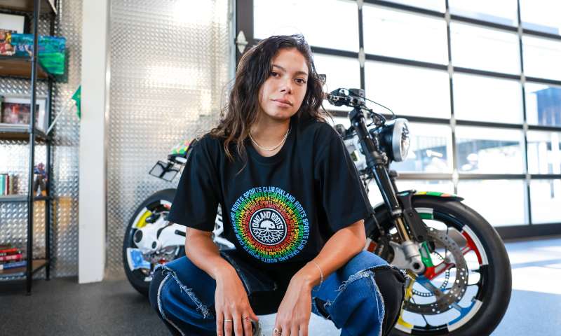 Woman posing with their Oakland Roots gear - shop now