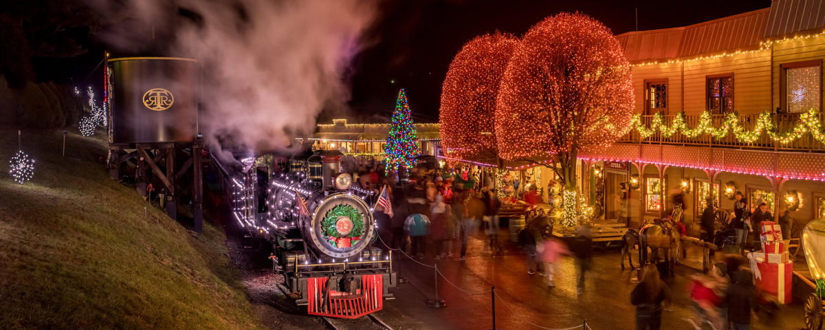 Bright glittering christmas lights adorn every surface of buildings, trees, and the iconic train at Tweetsie Railroad during their annual Tweetsie Christmas event.