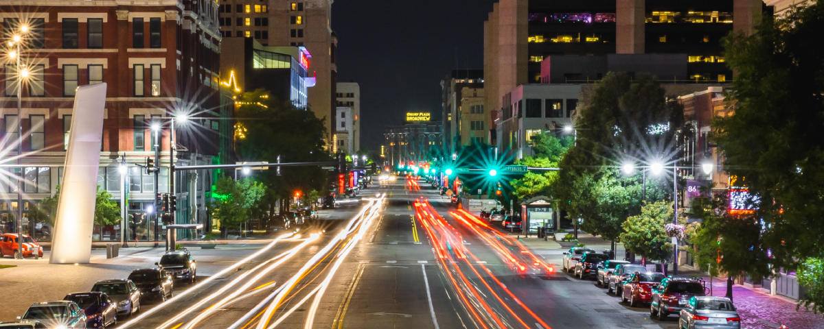 Cars drive down Douglas Avenue in downtown Wichita at night