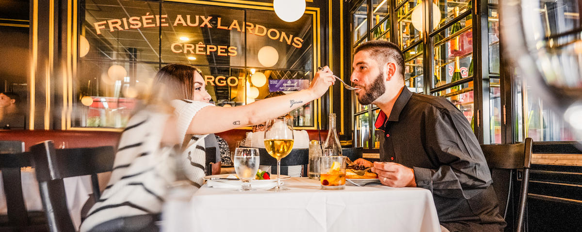A woman feeds a man a bite of food at George's French Bistro.