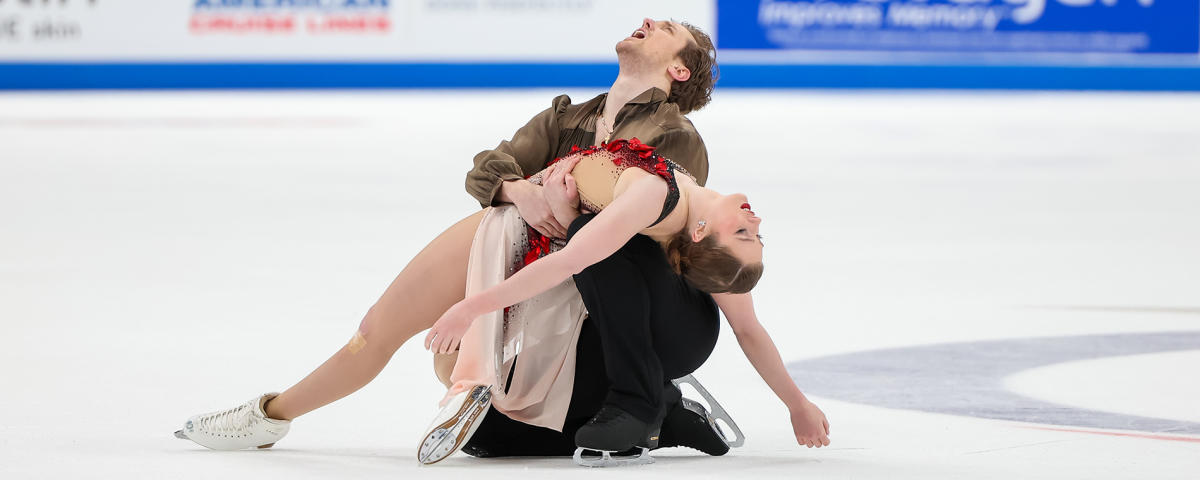 A male and female figure skater perform on the ice