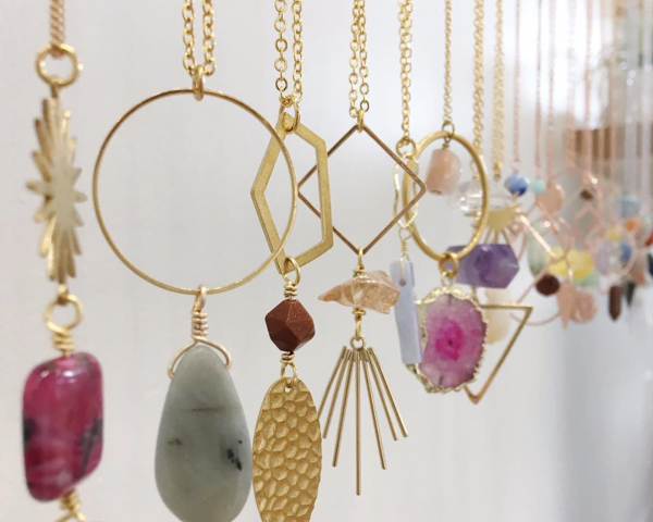 Dangling pendant necklaces featuring multicolored stones and metals
