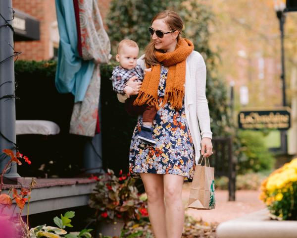 Woman carrying her baby down the leave covered streets in Historic Dublin