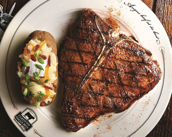 A grilled T-bone steak with a loaded baked potato from Saltgrass Steakhouse.