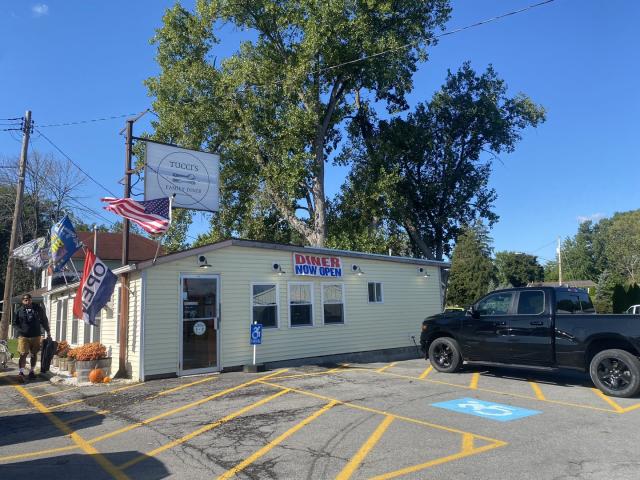The entrance to Tucci’s Family Diner situated in front of a green tree in Waterloo, NY.
