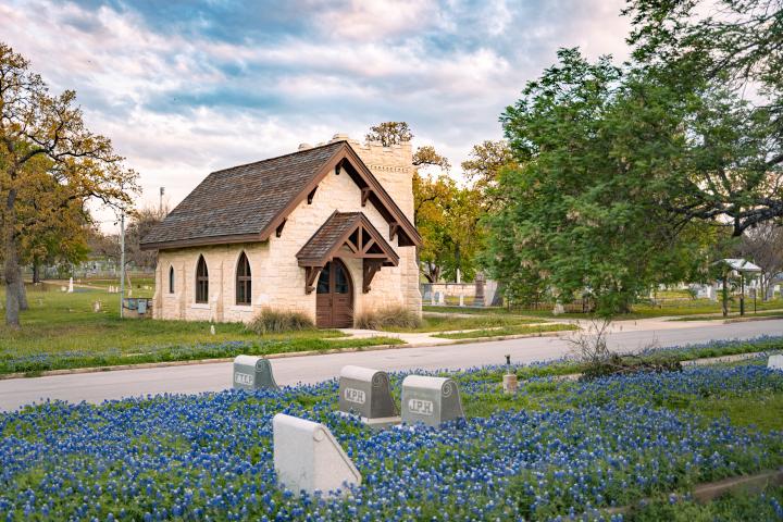 Chapel at Oakwood Cemetery behind a field of bluebonnets.