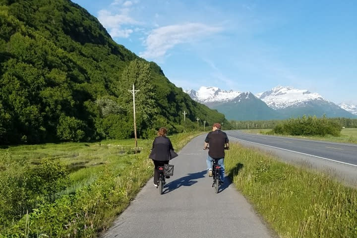 a couple rides bikes on a scenic bike path